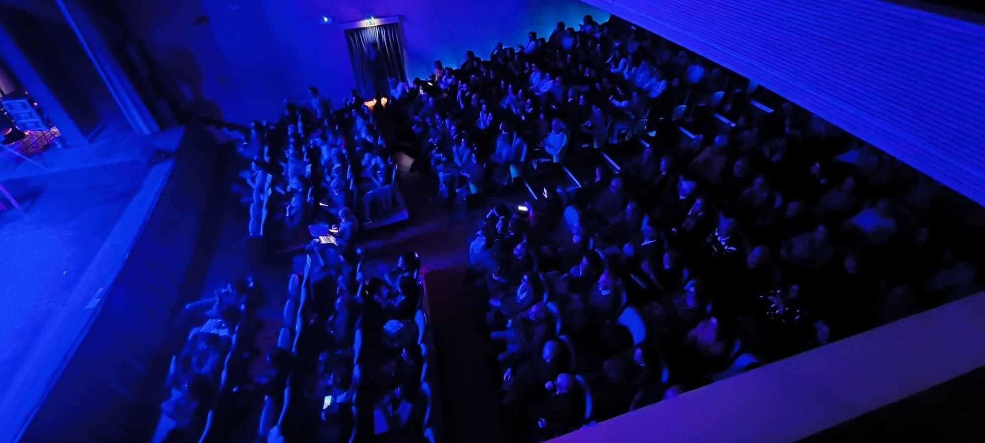 foto della platea presente al teatro il 12 dicembre 2025 con luce blu